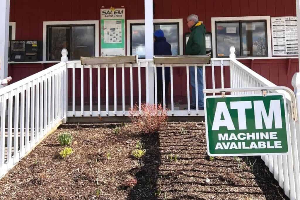 sign in front of salem valley farms that reads atm machine available.