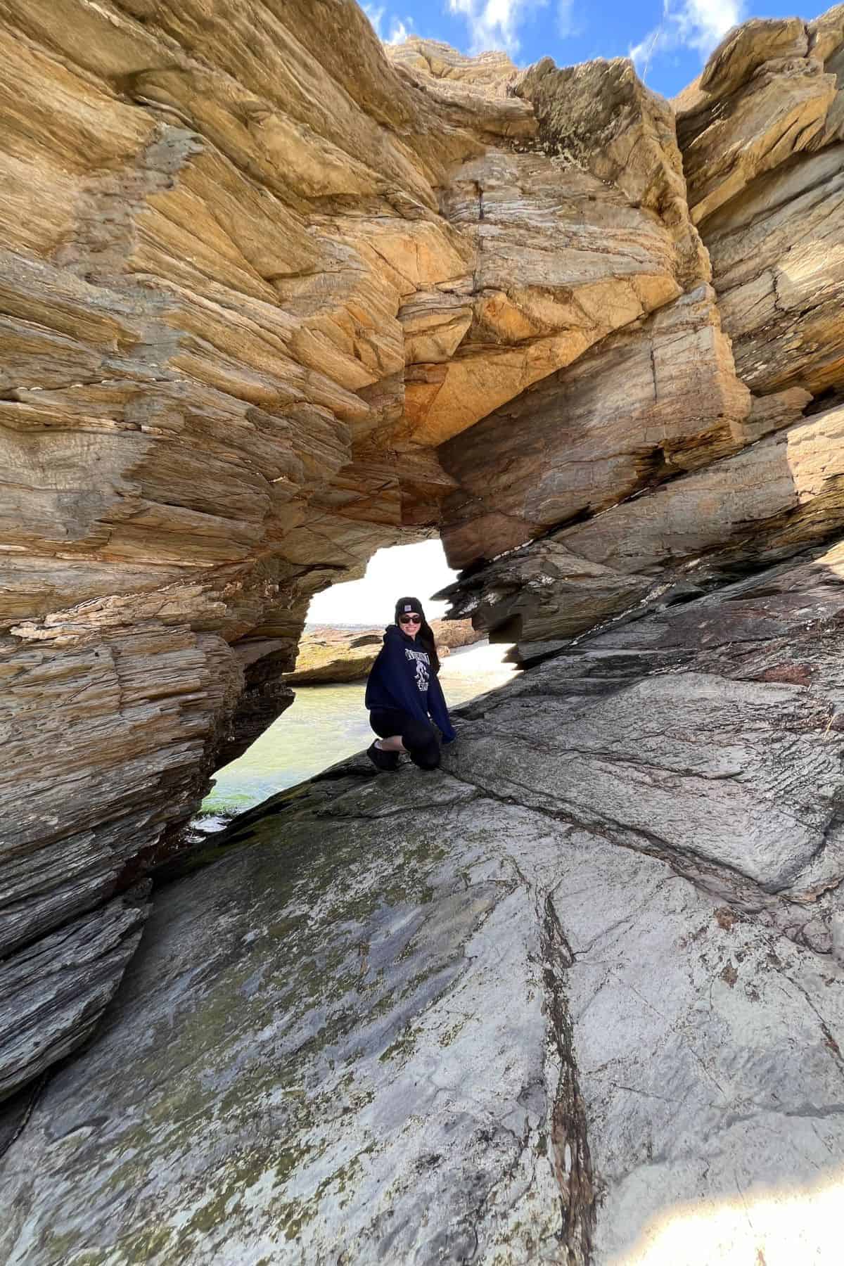 girl posing in rock hole at beavertail state park.