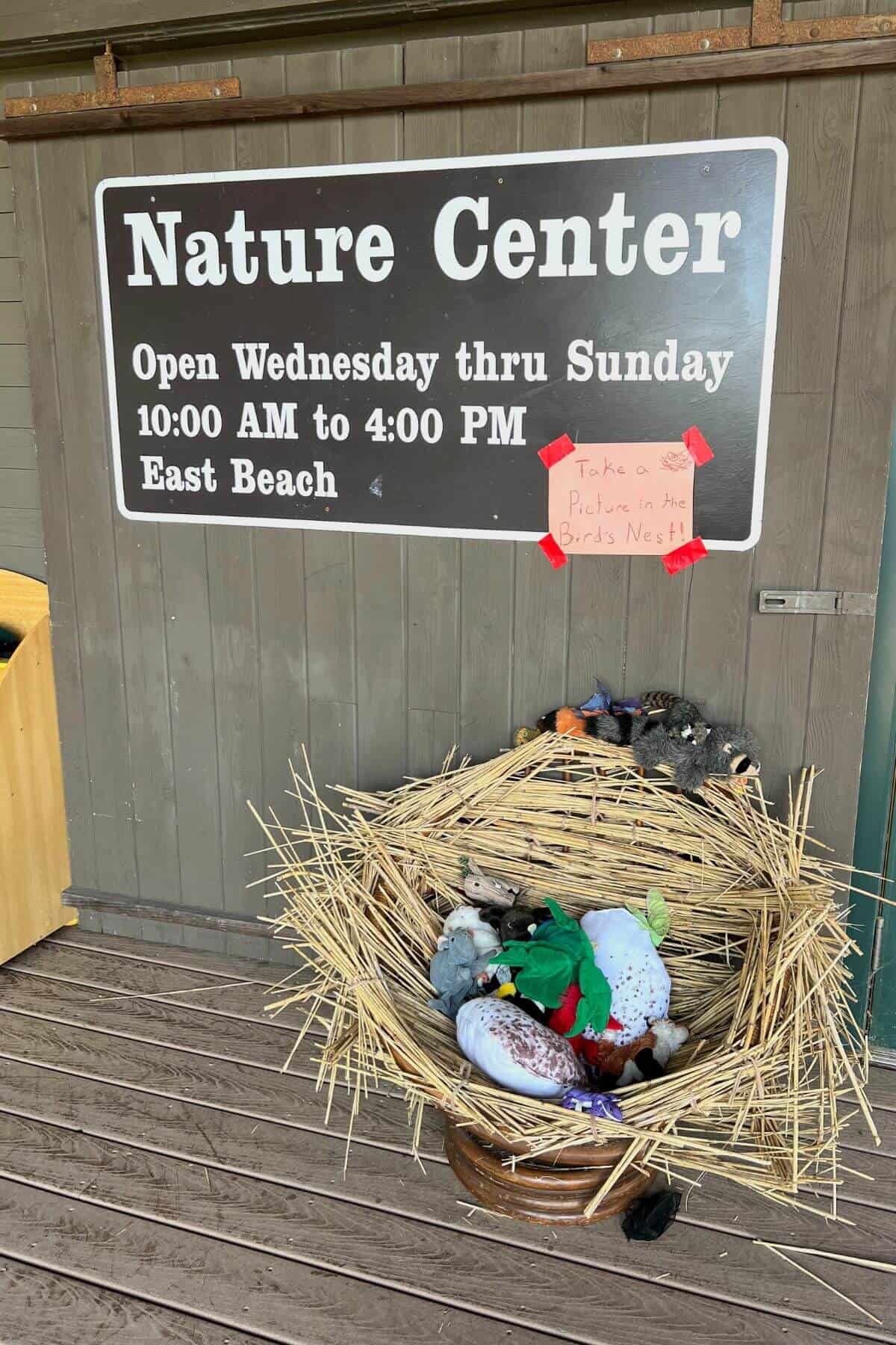 nature center sign with hours on it.
