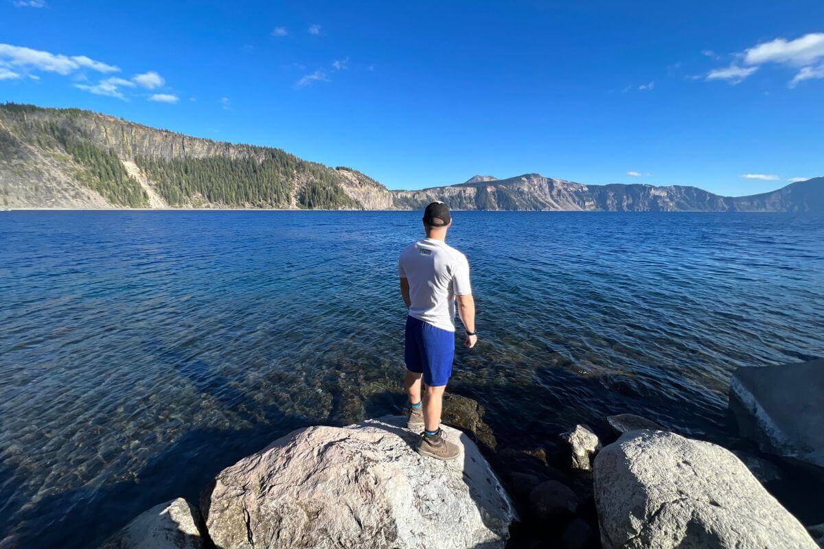 standing on rock along lake shoreline.