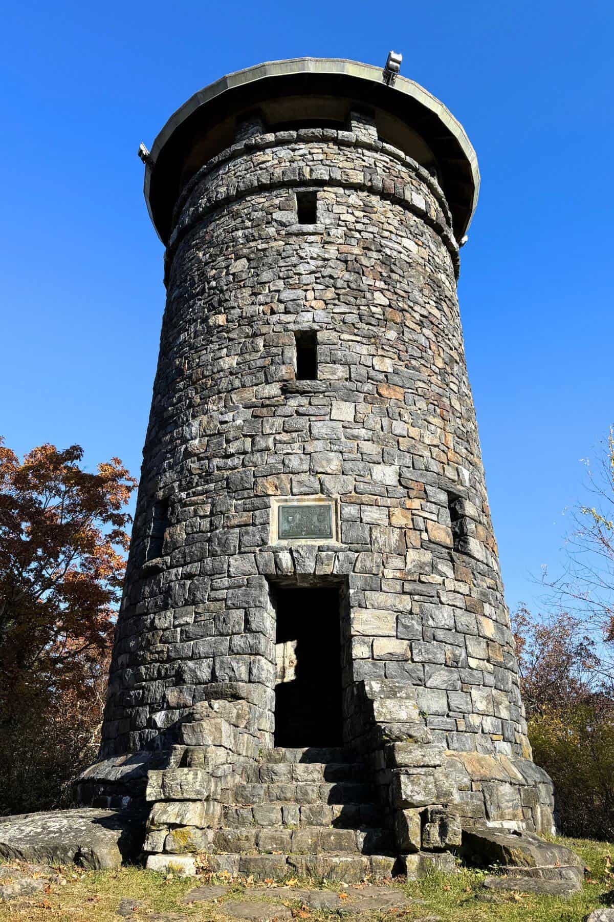 A stone tower sits on top of a hill.