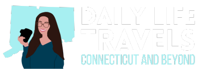 Illustration of a smiling woman holding a camera in front of a Connecticut map, with the text "Daily Life Travels Connecticut and Beyond.