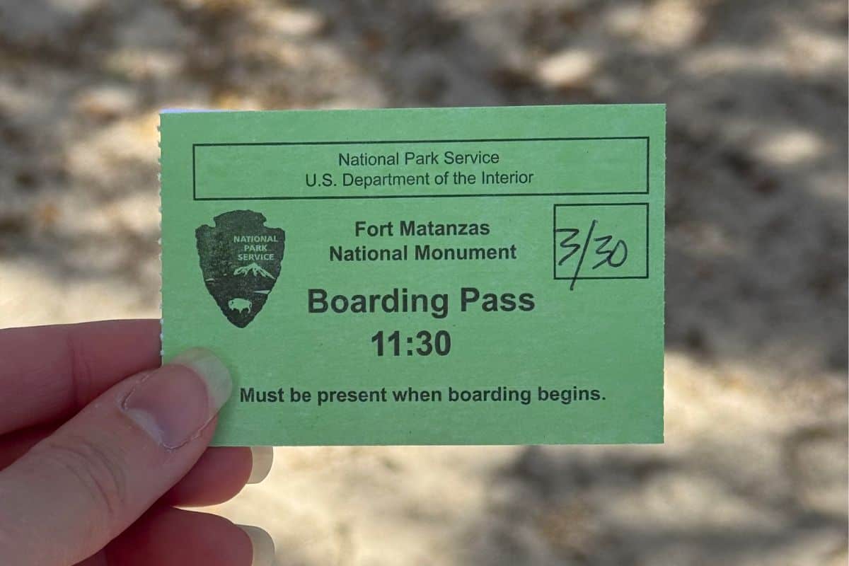 A hand holds a green Fort Matanzas National Monument boarding pass for 11:30, dated 3/30, issued by the National Park Service.