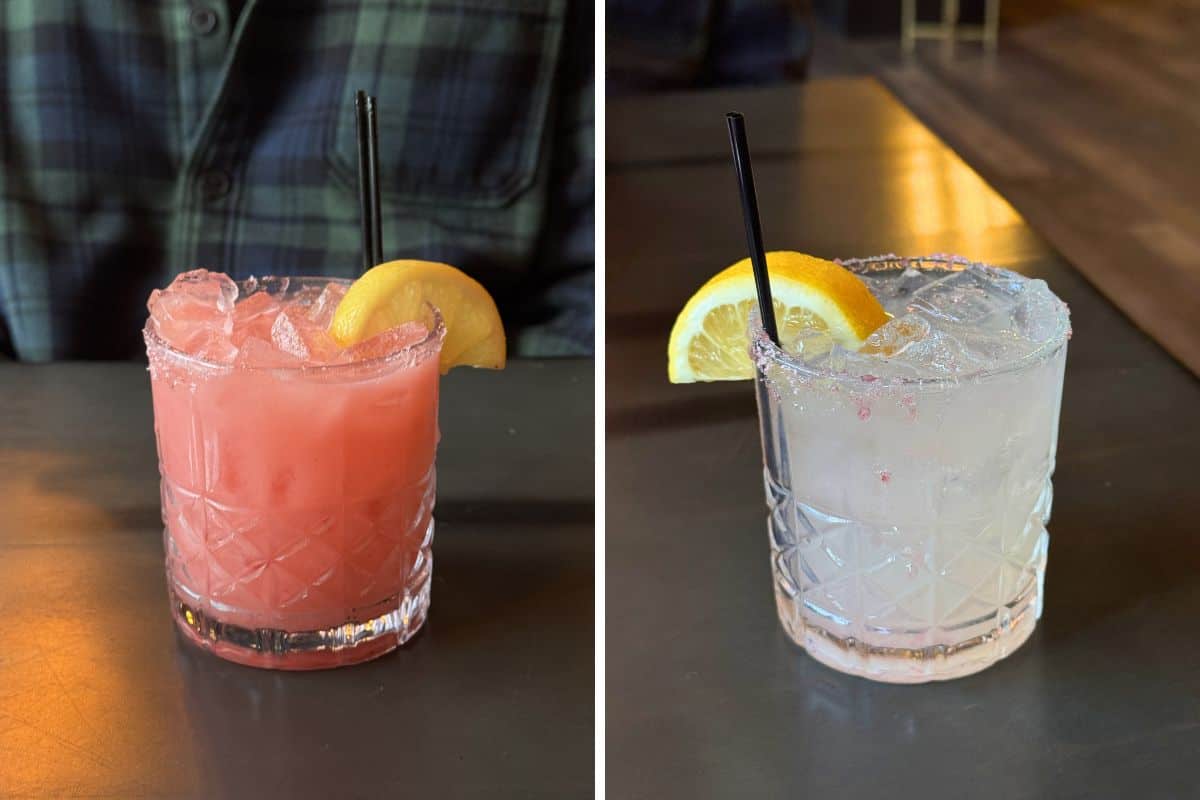 Two cocktails in short glasses with ice, each garnished with a lemon wedge and black straw; one drink is pink, the other is clear.