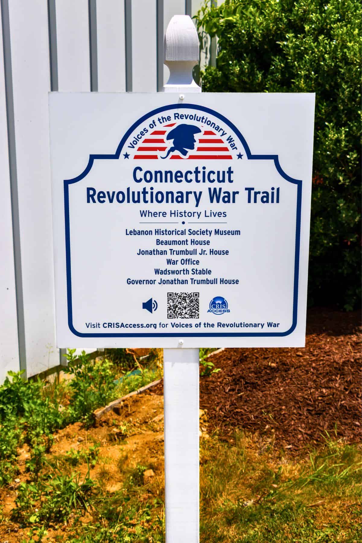 A sign for the Connecticut Revolutionary War Trail lists historical sites and features a blue and red logo of a silhouette in profile with stars.